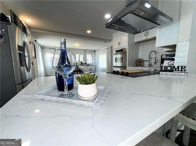 2638 Cleburne Pkwy, Powder Springs, GA 30127 - kitchen featuring appliances with stainless steel finishes, light stone counters, range hood, and a sink