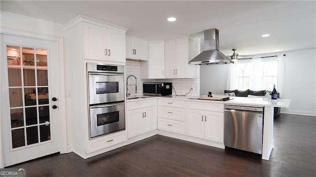 2638 Cleburne Pkwy, Powder Springs, GA 30127 - kitchen with stainless steel appliances, wall chimney range hood, dark wood finished floors, white cabinetry, and light countertops