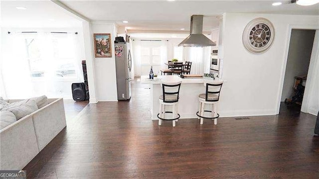 2638 Cleburne Pkwy, Powder Springs, GA 30127 - kitchen with freestanding refrigerator, white oven, dark wood-style floors, and island exhaust hood