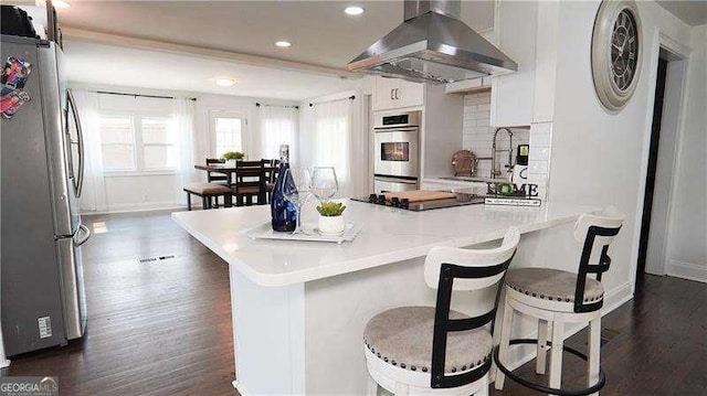2638 Cleburne Pkwy, Powder Springs, GA 30127 - kitchen with a breakfast bar, stainless steel appliances, range hood, and dark wood finished floors