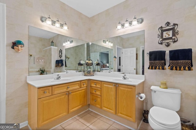 full bathroom featuring tile patterned flooring, double vanity, toilet, and tile walls