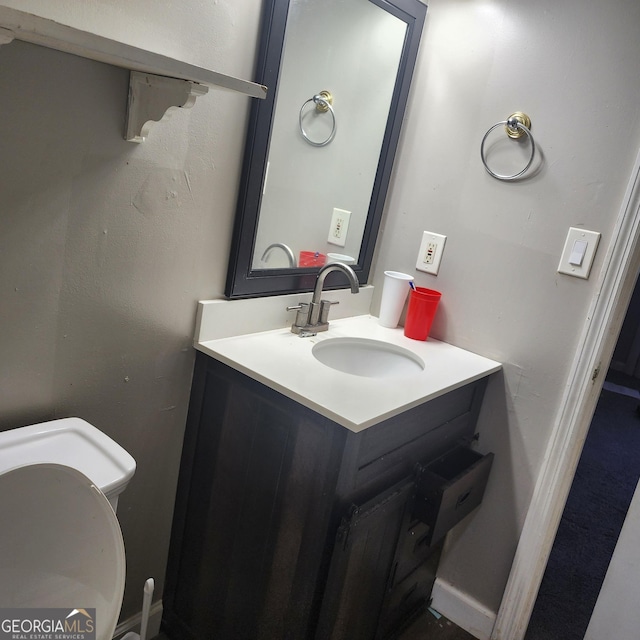 bathroom featuring toilet and vanity
