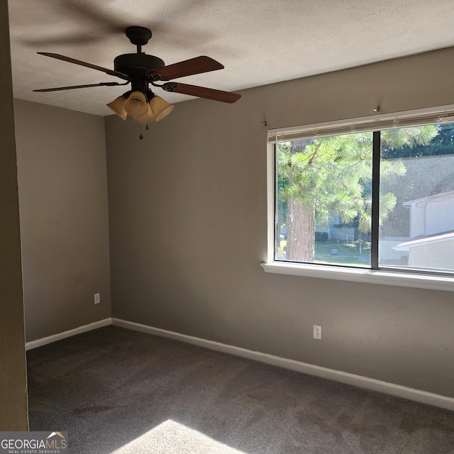 carpeted spare room with ceiling fan and baseboards