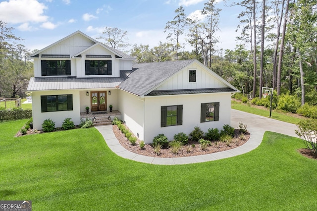 modern farmhouse style home with french doors, metal roof, a front lawn, board and batten siding, and a standing seam roof