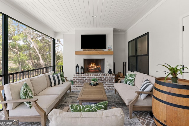 sunroom with an outdoor living space with a fireplace and plenty of natural light