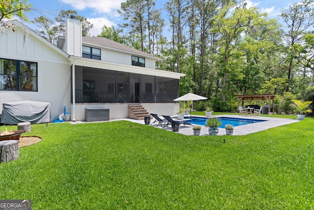 back of property featuring central air condition unit, a patio area, an outdoor pool, a lawn, and a sunroom