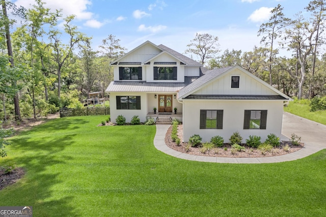 view of front facade featuring french doors, metal roof, a front lawn, board and batten siding, and a standing seam roof