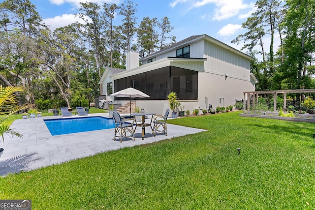 outdoor pool with a vegetable garden, a patio area, a sunroom, and a lawn