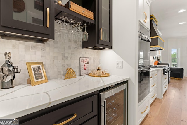 kitchen featuring light wood-style flooring, white cabinets, glass insert cabinets, and beverage cooler
