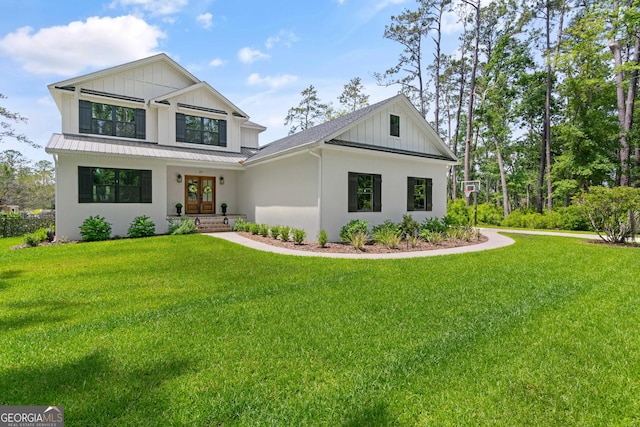 modern inspired farmhouse featuring board and batten siding, stucco siding, french doors, and a front yard