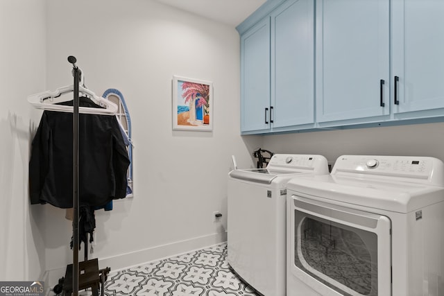 laundry room with baseboards, washing machine and dryer, and cabinet space