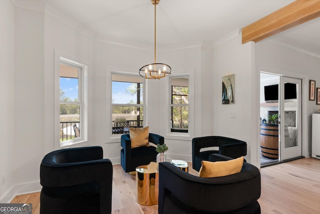 sitting room with a chandelier, light wood-style flooring, a healthy amount of sunlight, and ornamental molding