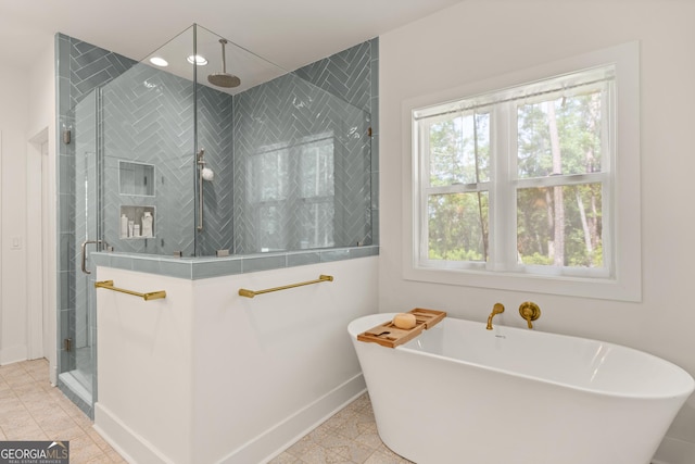 bathroom featuring a freestanding bath, baseboards, and a shower stall