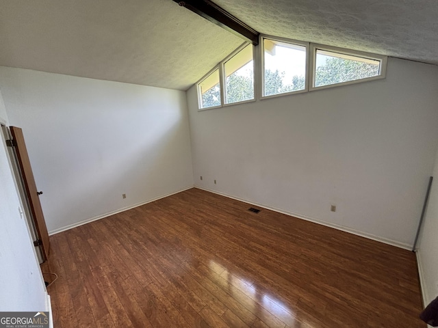 spare room featuring wood finished floors, baseboards, and plenty of natural light