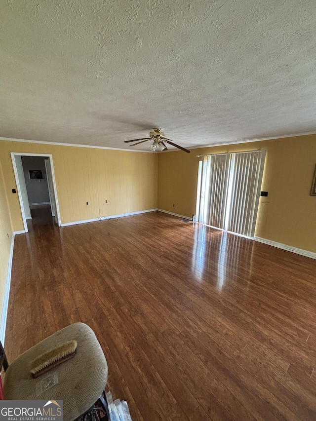 unfurnished living room featuring a textured ceiling, wood finished floors, a ceiling fan, baseboards, and crown molding