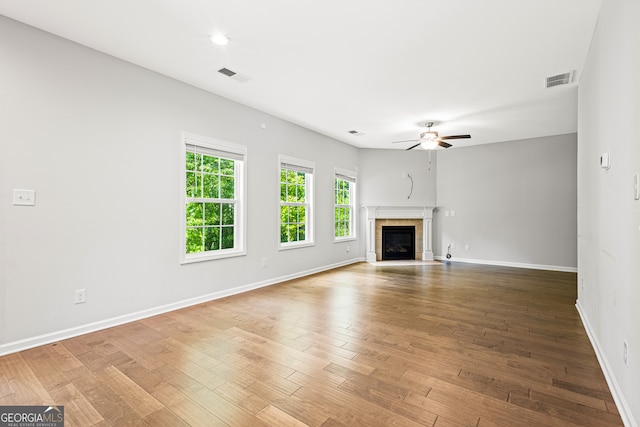 126 Ashton Pl, Newnan, GA 30265 - unfurnished living room featuring baseboards, ceiling fan, visible vents, wood finished floors, and a fireplace