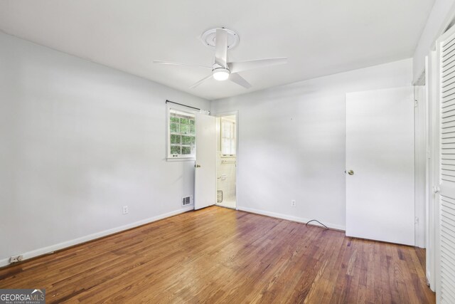 4074 Idlevale Dr, Tucker, GA 30084 - unfurnished bedroom featuring wood finished floors, ensuite bath, visible vents, ceiling fan, and baseboards