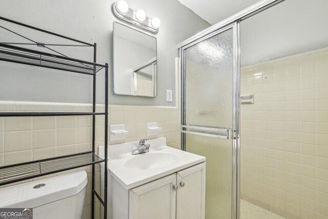 4074 Idlevale Dr, Tucker, GA 30084 - bathroom with tile walls, toilet, a shower stall, vanity, and a wainscoted wall