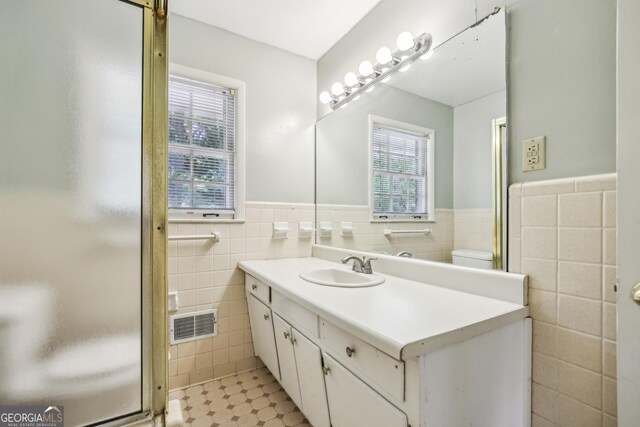 4074 Idlevale Dr, Tucker, GA 30084 - full bath featuring tile walls, vanity, visible vents, a shower stall, and wainscoting