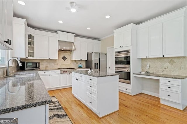 kitchen featuring appliances with stainless steel finishes, a sink, decorative backsplash, white cabinets, and recessed lighting