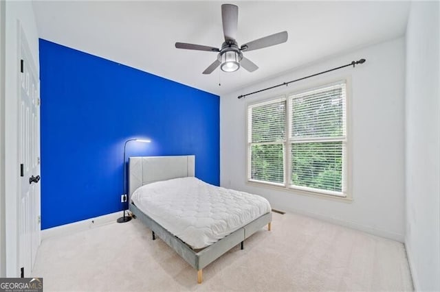 carpeted bedroom with baseboards and a ceiling fan