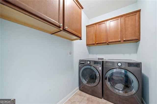laundry room featuring cabinet space, washer and dryer, and baseboards