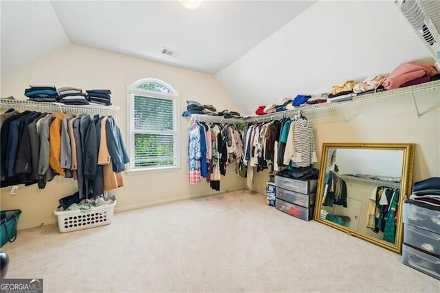 walk in closet with vaulted ceiling and carpet floors