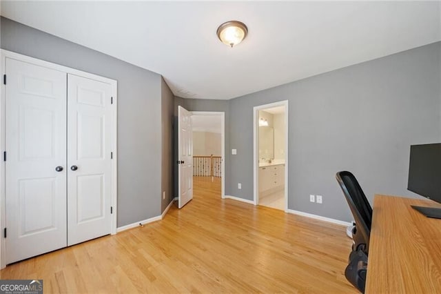 unfurnished office featuring light wood-style flooring and baseboards