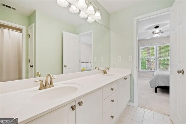 ensuite bathroom featuring tile patterned floors, double vanity, baseboards, and a ceiling fan