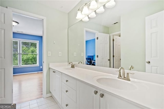 full bath featuring double vanity, tile patterned flooring, and baseboards