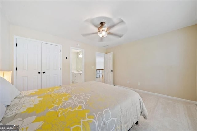 bedroom featuring carpet, a closet, baseboards, ensuite bathroom, and ceiling fan