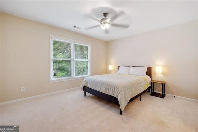 bedroom with light colored carpet, baseboards, and ceiling fan