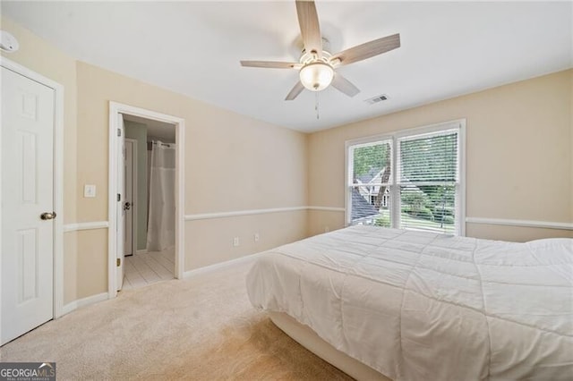 carpeted bedroom featuring baseboards, a ceiling fan, and ensuite bathroom