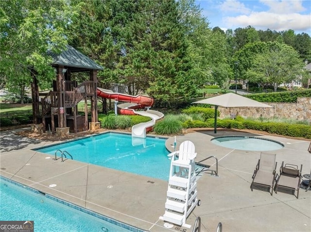 community pool featuring a water slide and a patio area
