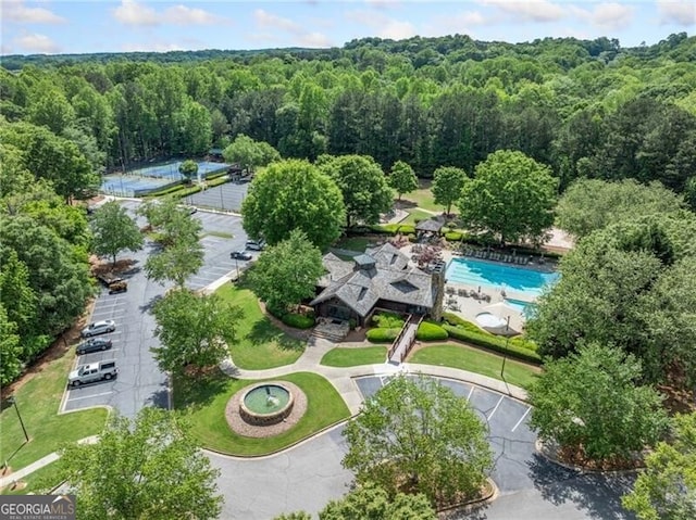 aerial view of a heavily wooded area and a pool area