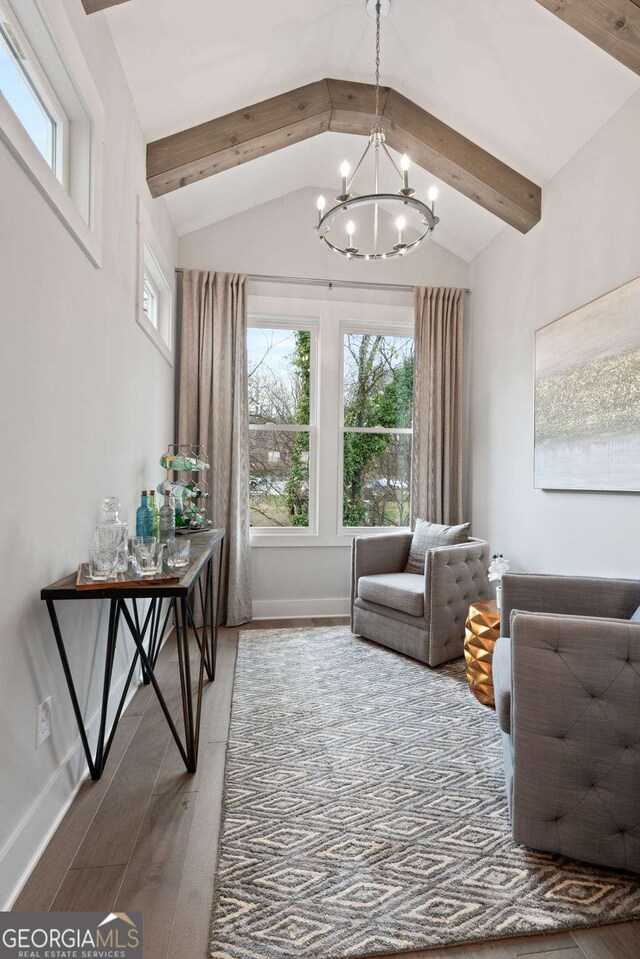 sitting room with baseboards, lofted ceiling with beams, a healthy amount of sunlight, and a chandelier