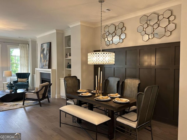 dining area featuring crown molding, wood-type flooring, visible vents, and built in shelves