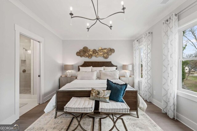 bedroom with baseboards, a chandelier, connected bathroom, and wood finished floors