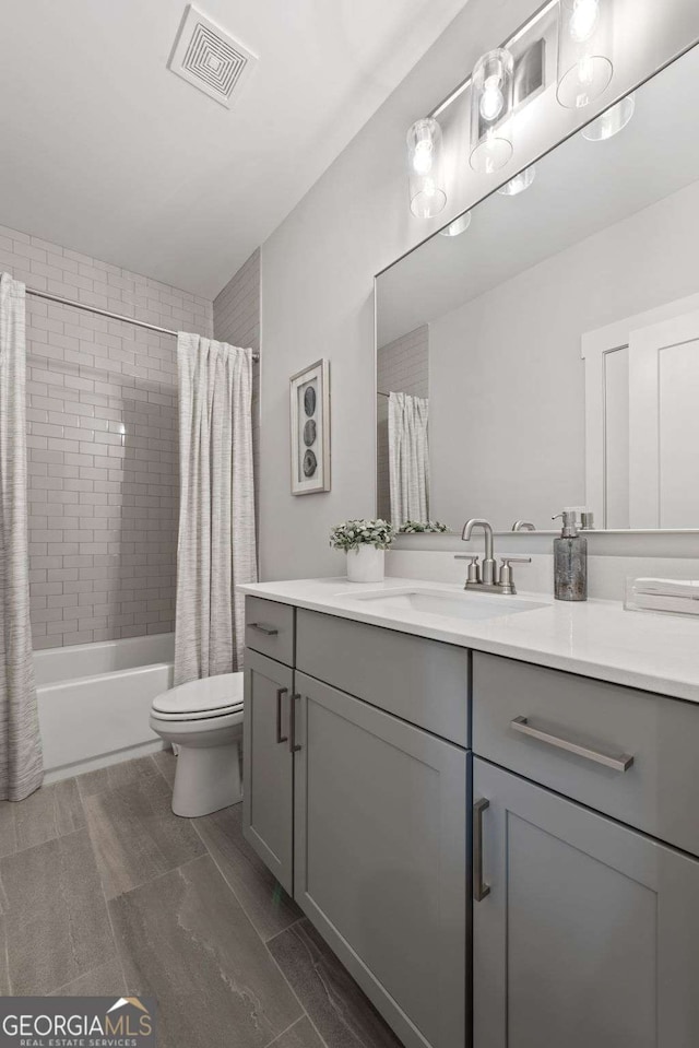 bathroom featuring toilet, vanity, visible vents, and shower / bath combination with curtain