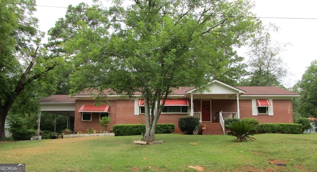 ranch-style home featuring brick siding, a front lawn, and a carport