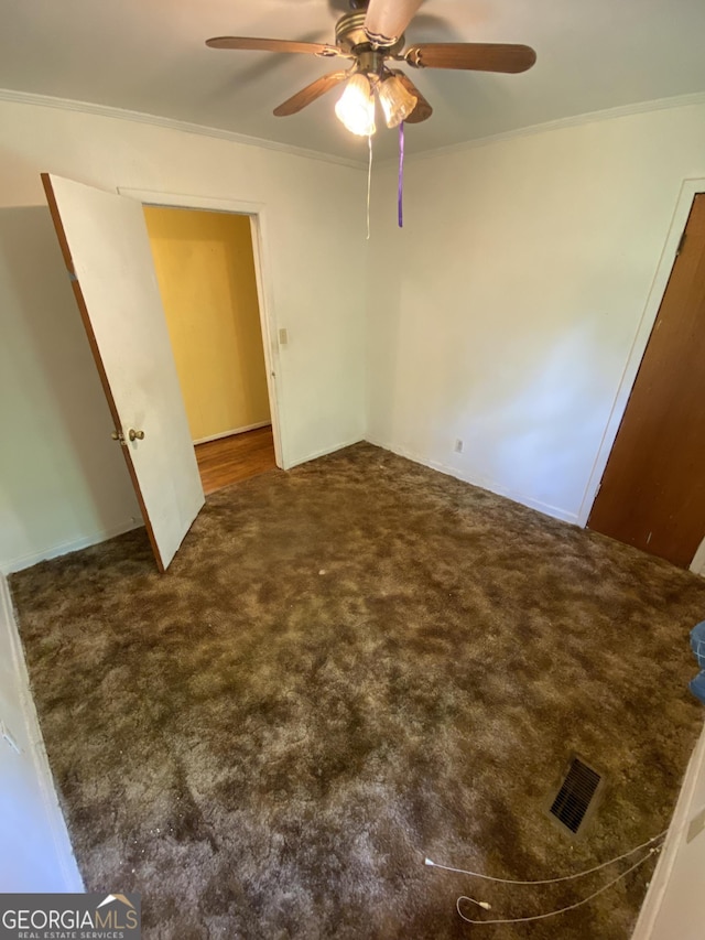unfurnished bedroom with carpet floors, ornamental molding, and ceiling fan