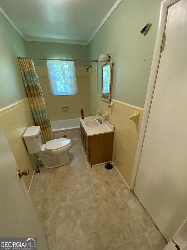 bathroom with toilet, tile walls, shower / bath combo, ornamental molding, and vanity
