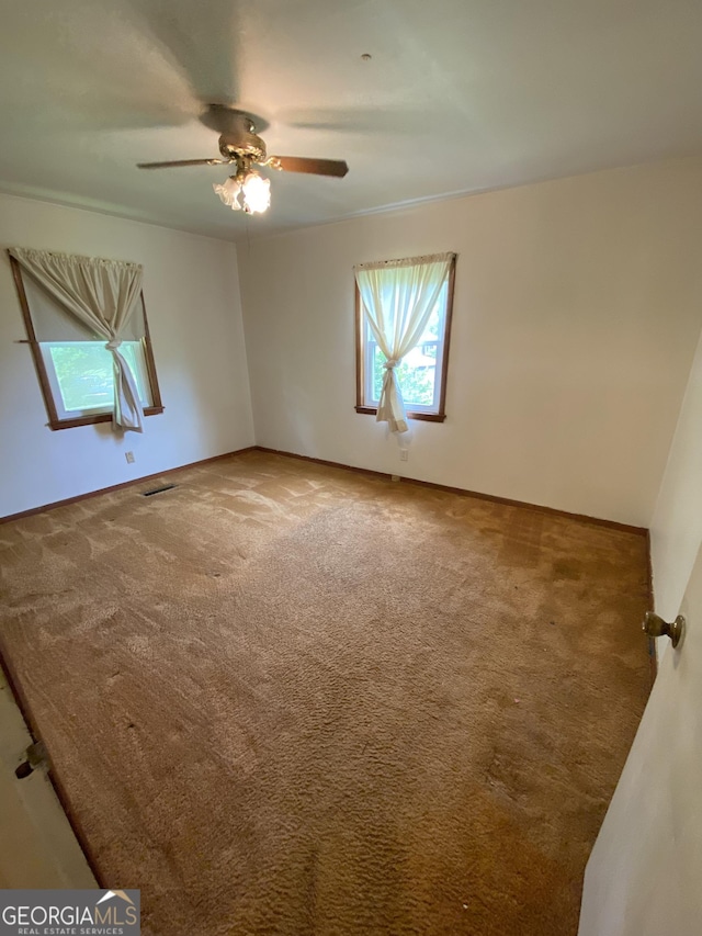 carpeted empty room featuring a ceiling fan