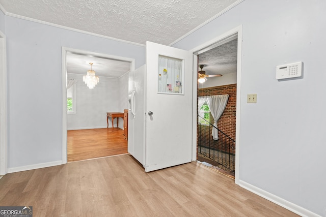 119 Blount St, Forsyth, GA 31029 - empty room featuring light wood-style flooring, a textured ceiling, crown molding, a ceiling fan, and a chandelier