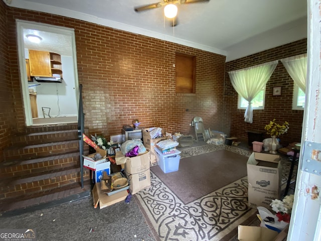 misc room with brick wall and ceiling fan