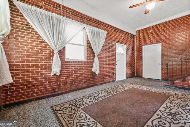 119 Blount St, Forsyth, GA 31029 - unfurnished living room featuring brick wall, ceiling fan, and speckle patterned floor
