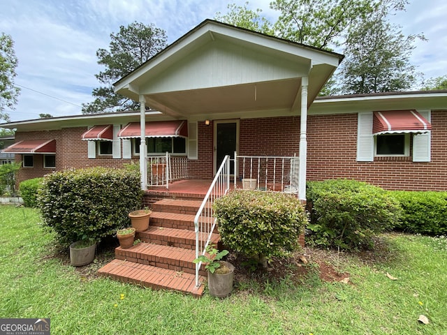 view of front facade with brick siding and a front lawn