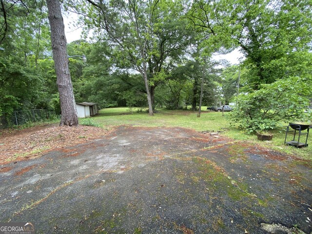 view of patio with a storage shed, an outdoor structure, and fence