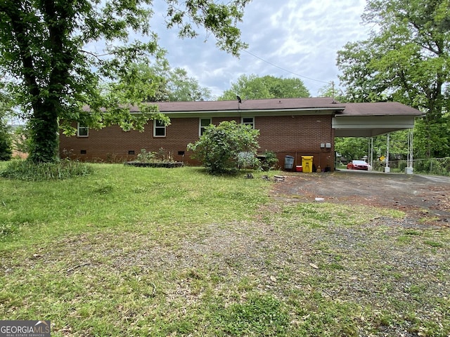 119 Blount St, Forsyth, GA 31029 - rear view of property featuring crawl space, a carport, driveway, brick siding, and a lawn