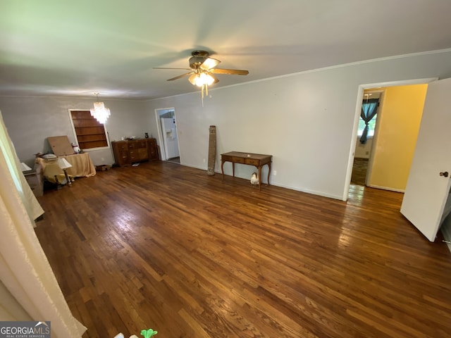 unfurnished living room with wood finished floors, a ceiling fan, ornamental molding, a chandelier, and baseboards